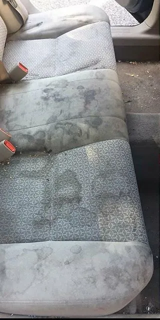 Auton takapenkki pahoin likaantuneena ennen pesua.